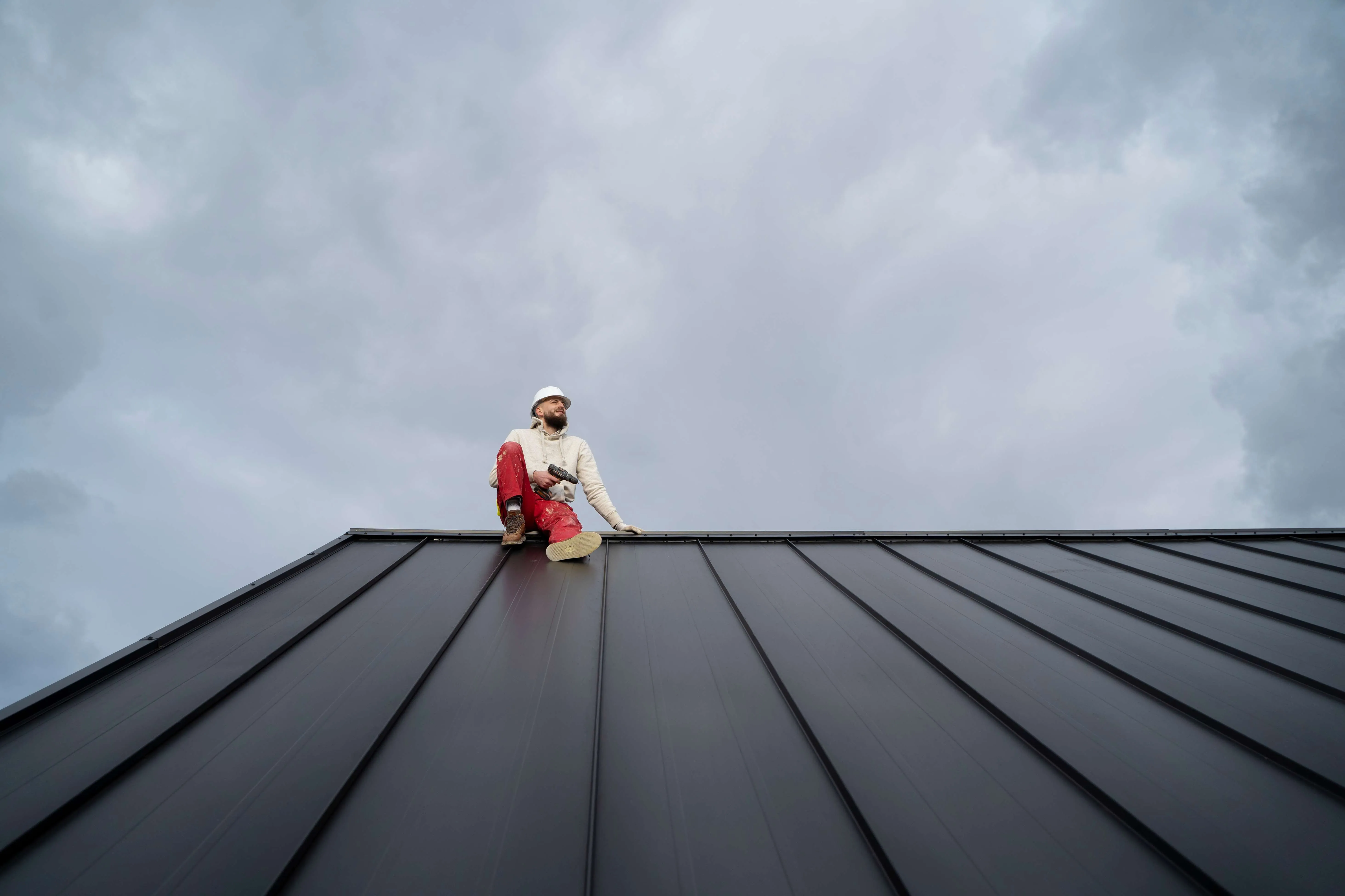Professional roofer applying waterproofing membrane on roof in Qatar